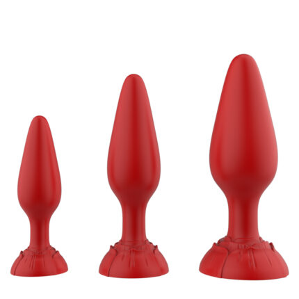 Three red cone-shaped anal plugs from the Rose Anal Plug Three-Piece Set are lined up in a row, arranged from smallest to largest. Each plug's base showcases a floral-like design.