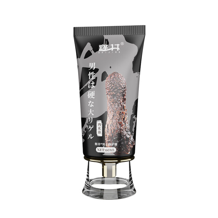 A black and gray tube labeled with Japanese text and adorned with an image of a tree branch contains the "Repair Cream For Men, Spongiform Conditioning To Reduce Turtle Head Sensitivity Desensitization Delay," featuring a clear cap. The prominently displayed text on the tube includes a white, mountain-shaped logo at the top.