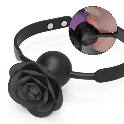 Introducing the Blazing Rose: a black, floral gag with a stunning rose-shaped centerpiece and an adjustable strap. An inset captures a close-up of someone wearing it, showcasing its intricate details and texture. The person's lips and the Blazing Rose gag are visible, with water droplets glistening on its surface.