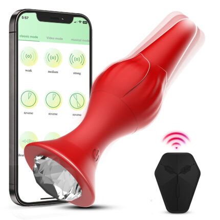 A rose-colored, rocket-shaped anal plug with a faceted, jewel-like base is depicted beside a smartphone displaying control options such as "classic mode" and "video mode." The plug is shown with vibrational waves, and a black remote with a signal icon is nearby. This product is an App-controlled, 9 frequency vibration wireless remote control charging massager designed for adult use.